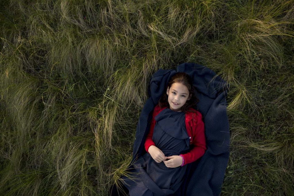 kislány, mező, fűben fekszik, szabadtéri fotózás, gyerekfotó, családfotó